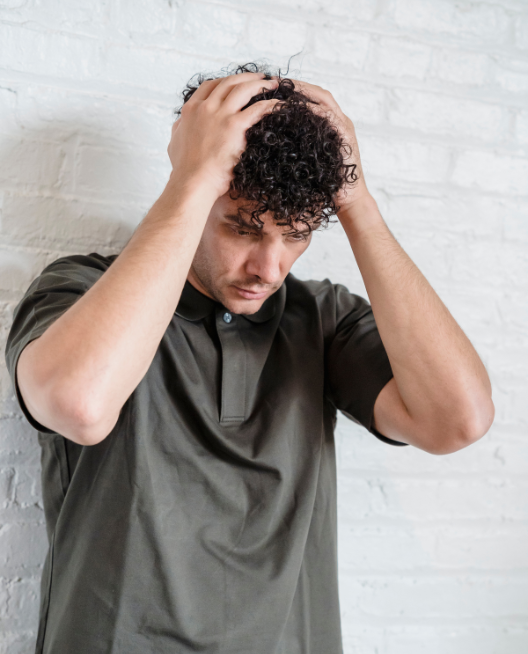 A man holding his head looking upset. He is filled with remorse after cheating. If you are experiencing infidelity guilt you can benefit from our Infidelity Recovery program in the USA, Canada and the UK. Schedule your consultation today.