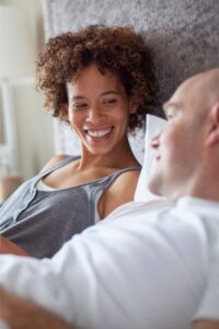 A woman smiling at her husband representing how couples can heal and reconnect through communication. Online programs can help you heal from betrayal trauma. Schedule a free consultation today. 