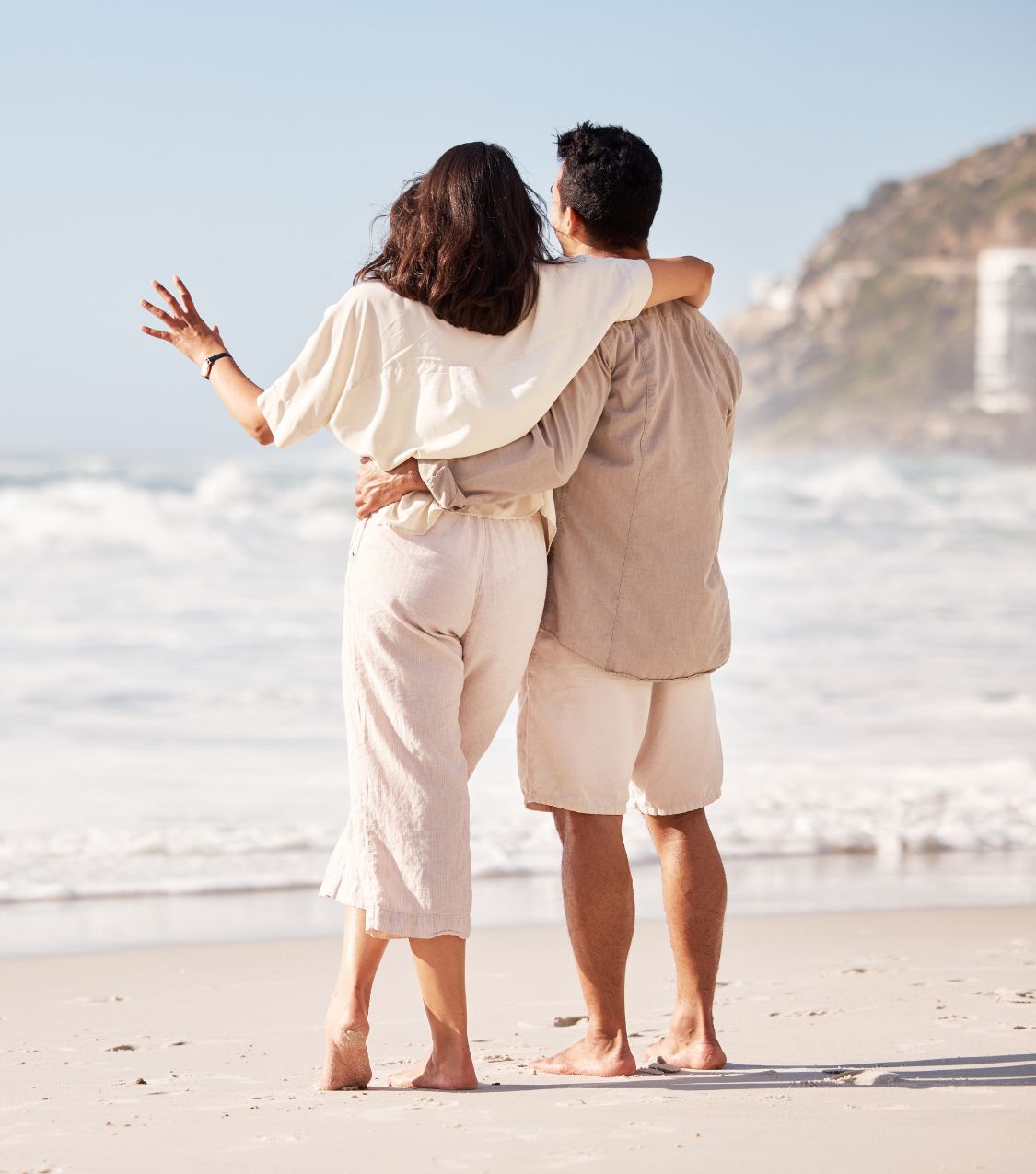 A couple on the beach hugging looking into the horizon discussing their surviving infidelity story. Your marriage can survive infidelity with the help of our Affair Recovery program. Schedule a free consultation with Relationship Experts today!
