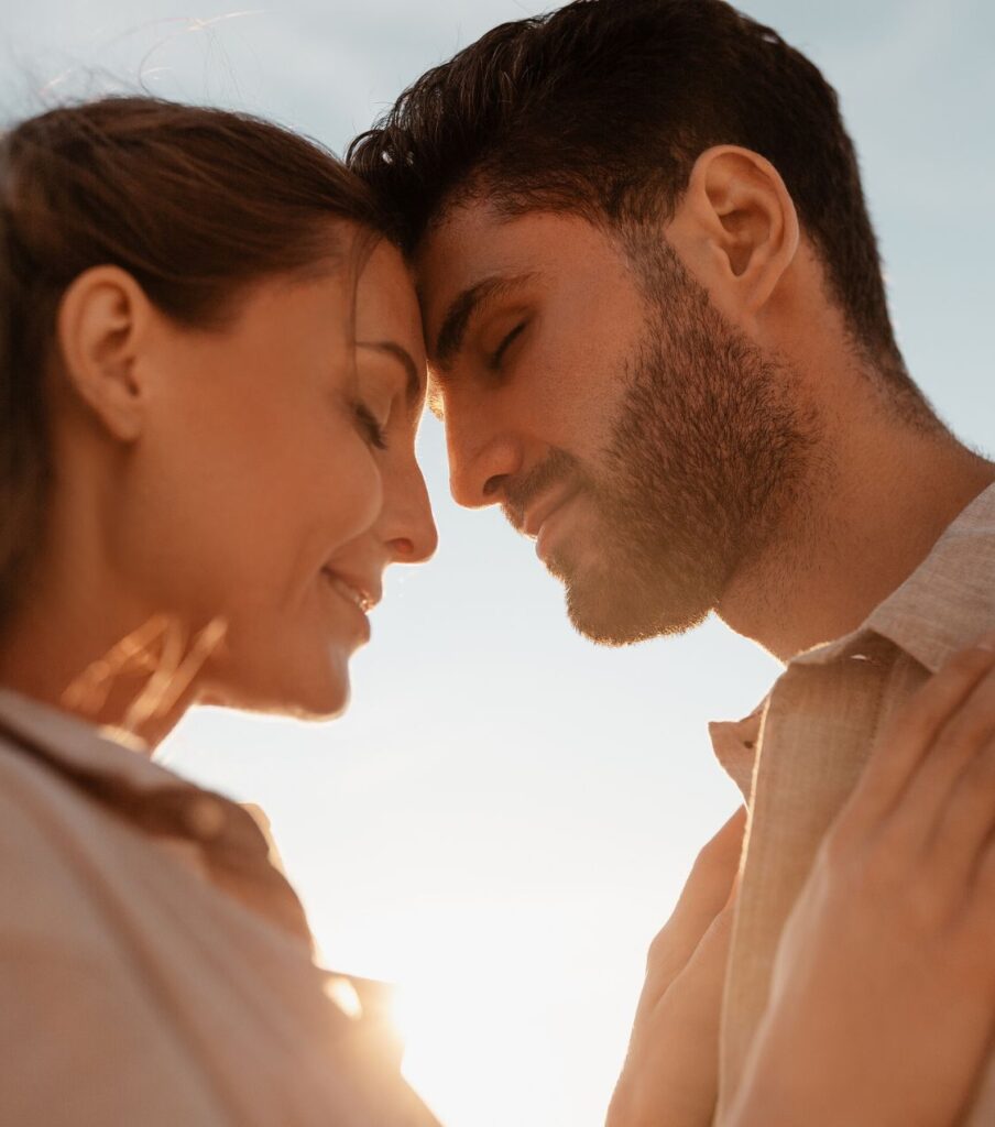 Couple with closed eyes head to head feeling hopeful after healing from the pain of infidelity. If you are in the aftermath of infidelity you can heal and visualize a brighter future together. Get more information by scheduling a free consultation. 