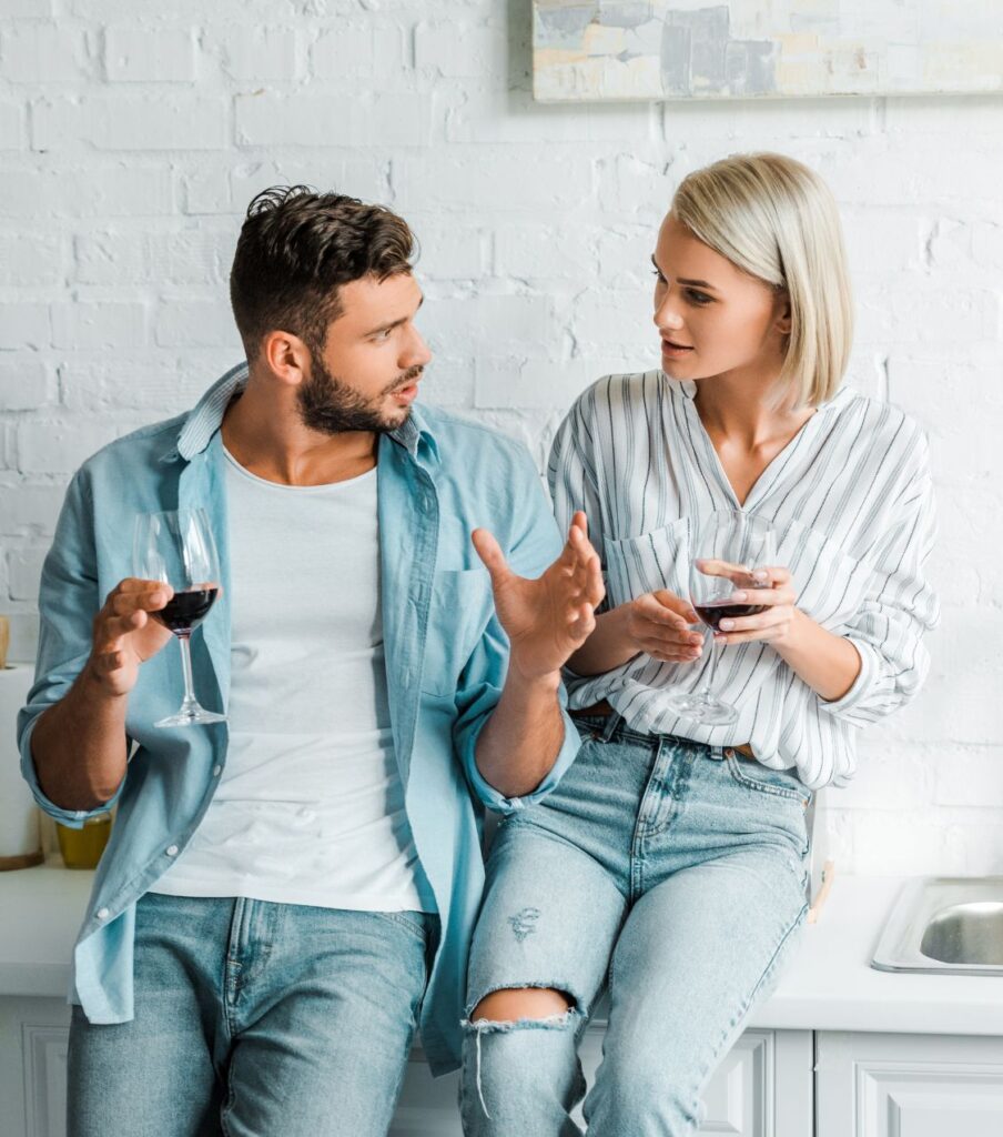 Couple talking while holding glasses of wine. Talking and sharing concerns can help save your relationship. By stoping conflict avoidance you can start healing and building trust. Relationship Experts in the United States & Canada can help couples heal and survive infidelity. Schedule a free consultation today. 