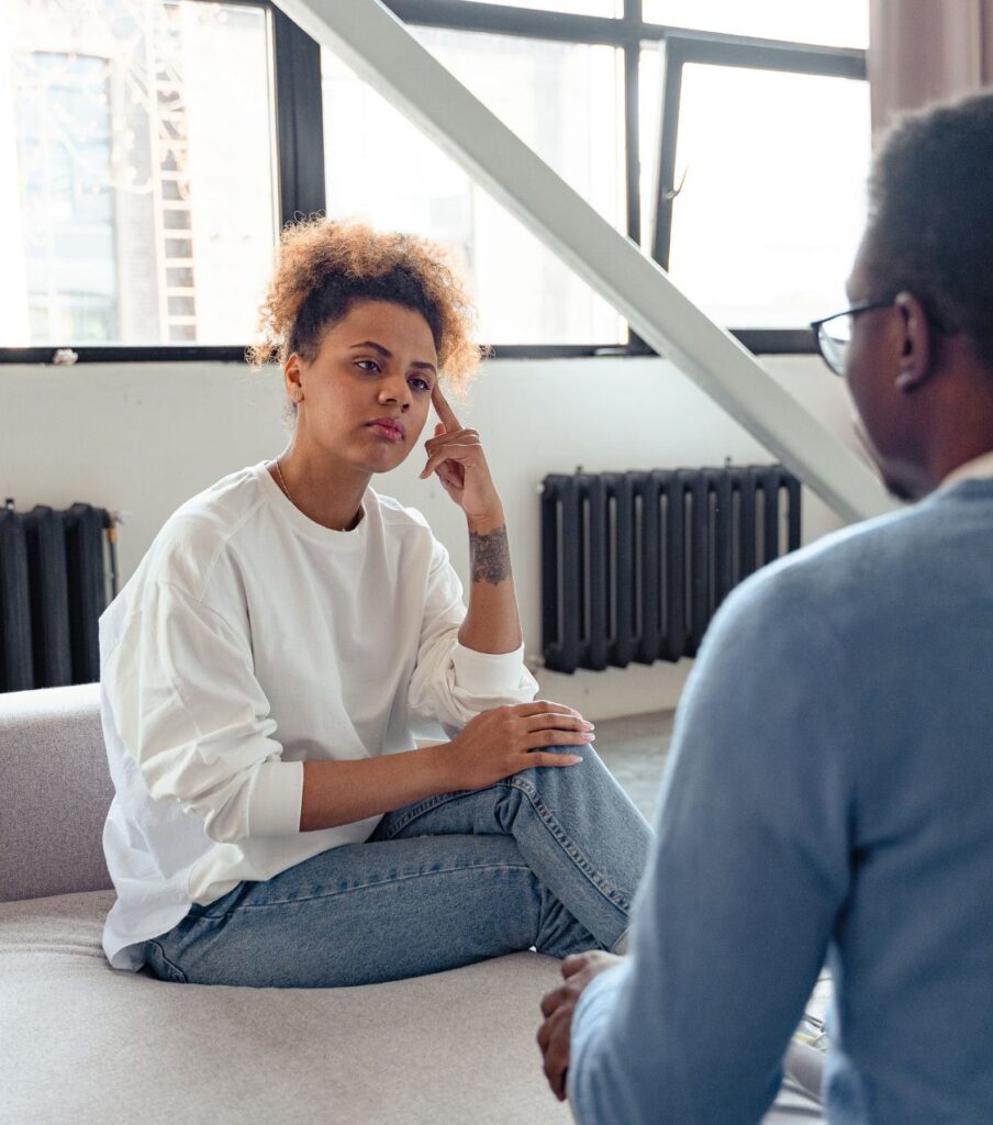 A woman sitting next to a man resting her head on her hand. She is listening to him. When recovering from an affair nondefensive listening is crucial. Learn more about recovering from an affair with relationship Experts Online based in Miami, Florida in the USA

