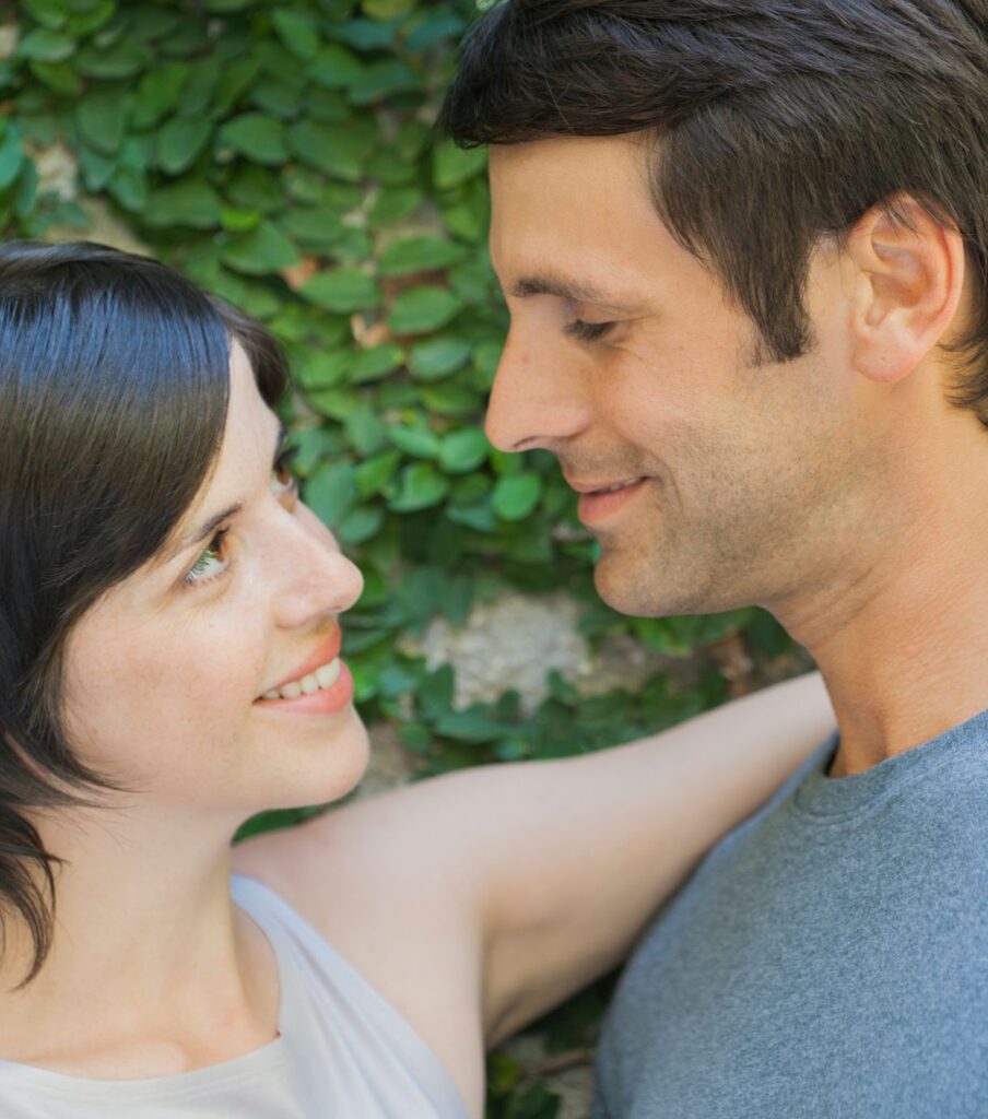 A woman & a man smiling, looking at each other admirably. Representing the feeling partners in the United States can feel, after finding the right guidance to handle betrayal trauma recovery. Schedule a free consultation today.
