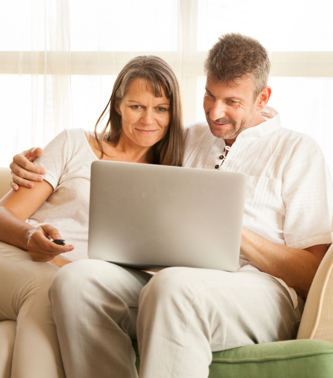 A couple, a woman, and a man sit closely, gazing at a laptop screen. Symbolizing a pair navigating the aftermath of infidelity, seeking solace through an infidelity recovery program. Initiate your healing journey by scheduling a free consultation with us today, available in the United States, New York, Colorado, North Carolina, Ohio, Toronto, Canada, California and globally.