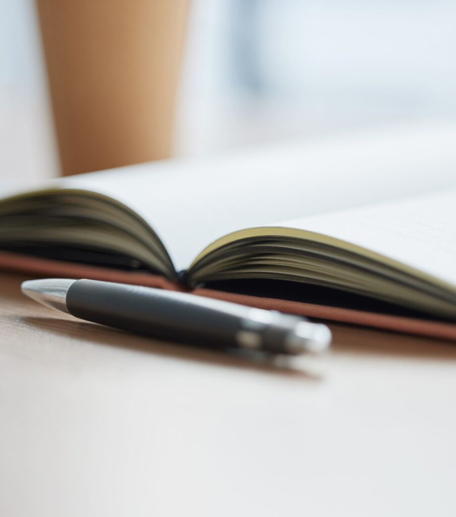 A pen next to a notebook, symbolizing the necessary work ahead. In the aftermath of infidelity, both partners must be willing to explore possibilities. Navigate the healing roadmap with my specialized affair recovery program. Serving couples in the United Kingdom, Canada, United States, and globally.


