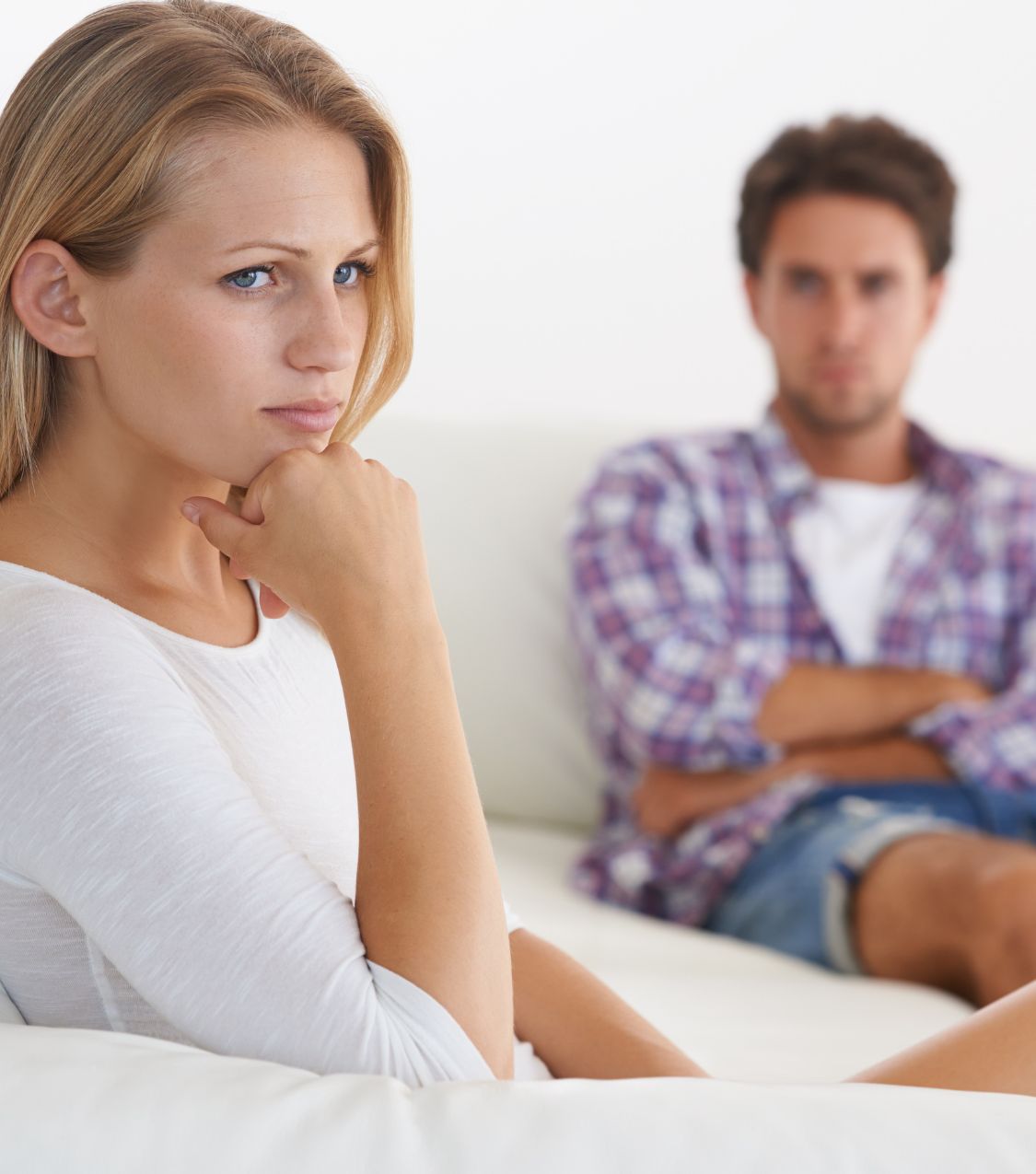 A woman gazes ahead, distancing herself from a blurred man figure behind her, depicting the aftermath of infidelity. Unsure how to apologize for cheating, we help couples nationwide, including California, Ohio, New York, Florida, and Colorado in the USA, as well as in Canada, the UK, and Australia. Book a consultation with us today!