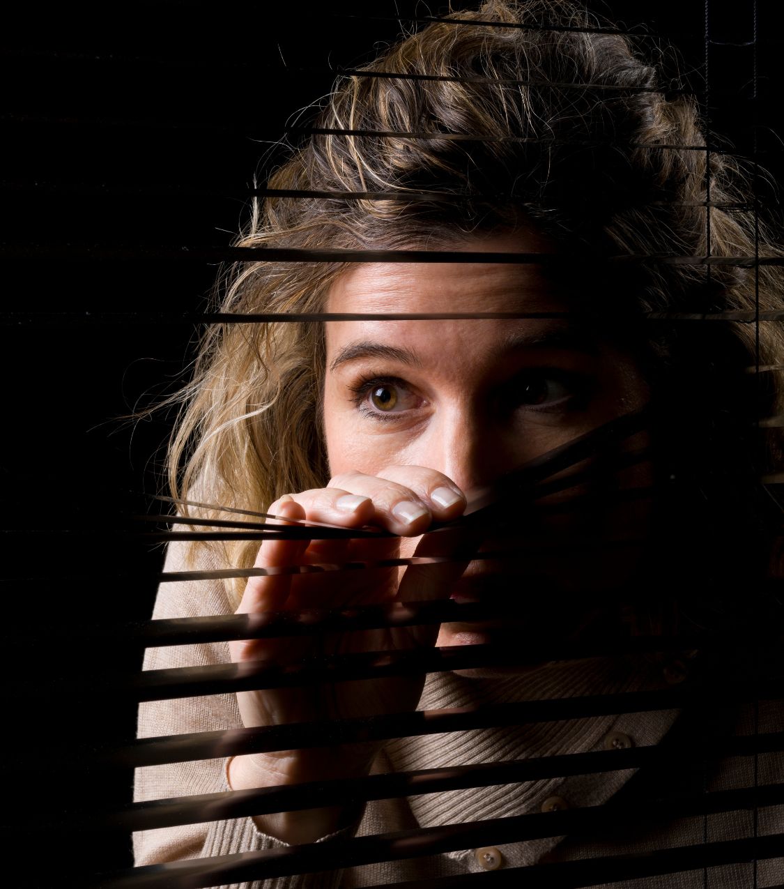 A woman peeking through blinds, representing the need for healing and transparency to reconcile after cheating. Contact Relationship Experts Online for marriage reconciliation guidance. Serving couples in North Carolina, the United States, Australia, Canada, and the United Kingdom.