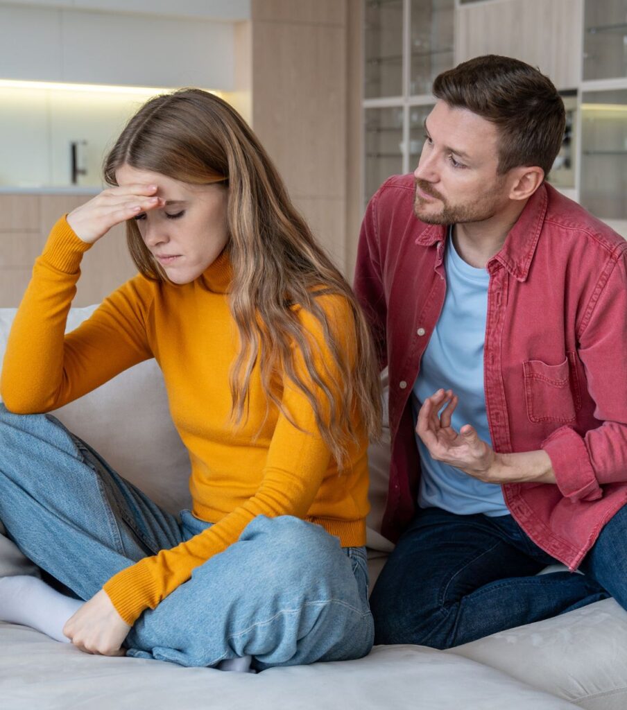 A woman with her hand on her forehead sits while a man tries to talk to her. Despite many reasons for cheating, partners often seek therapy to stay together. Relationship Experts can help. Schedule a consultation in Illinois, USA, Canada, Australia, the UK, and globally.