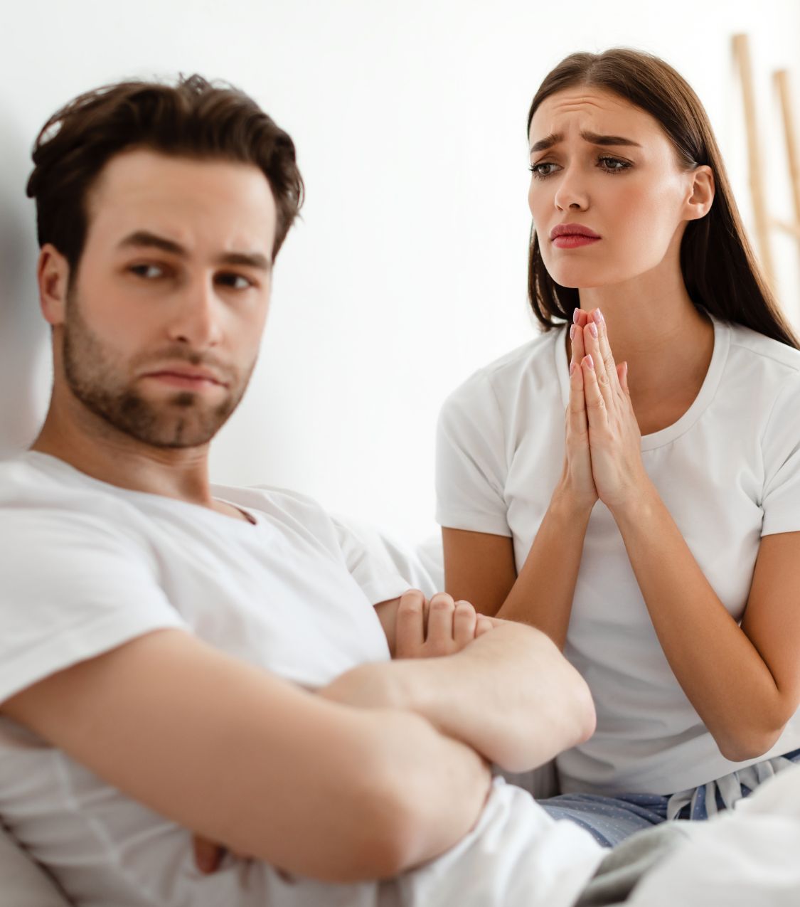 A man looking away from a woman making a begging gesture. Trust after infidelity is crucial for healing after cheating. Contact Relationship Experts for guidance in the US, Colorado, Canada, Australia, the UK, and globally.