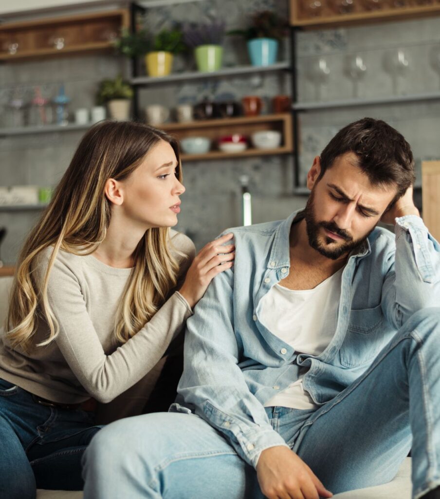 A woman holds the shoulder of an upset man, symbolizing a partner who knows how to apologize for cheating. Start your healing journey with our infidelity recovery program, available in Florida, New York, California, and globally. Schedule a free consultation today.