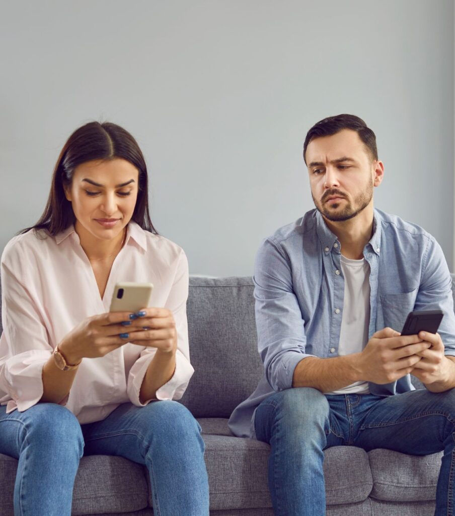 Couple sitting with cell phones, symbolizing incomplete truth. Honest communication is crucial for affair recovery. Contact Relationship Experts in California, New York, and worldwide for support.
