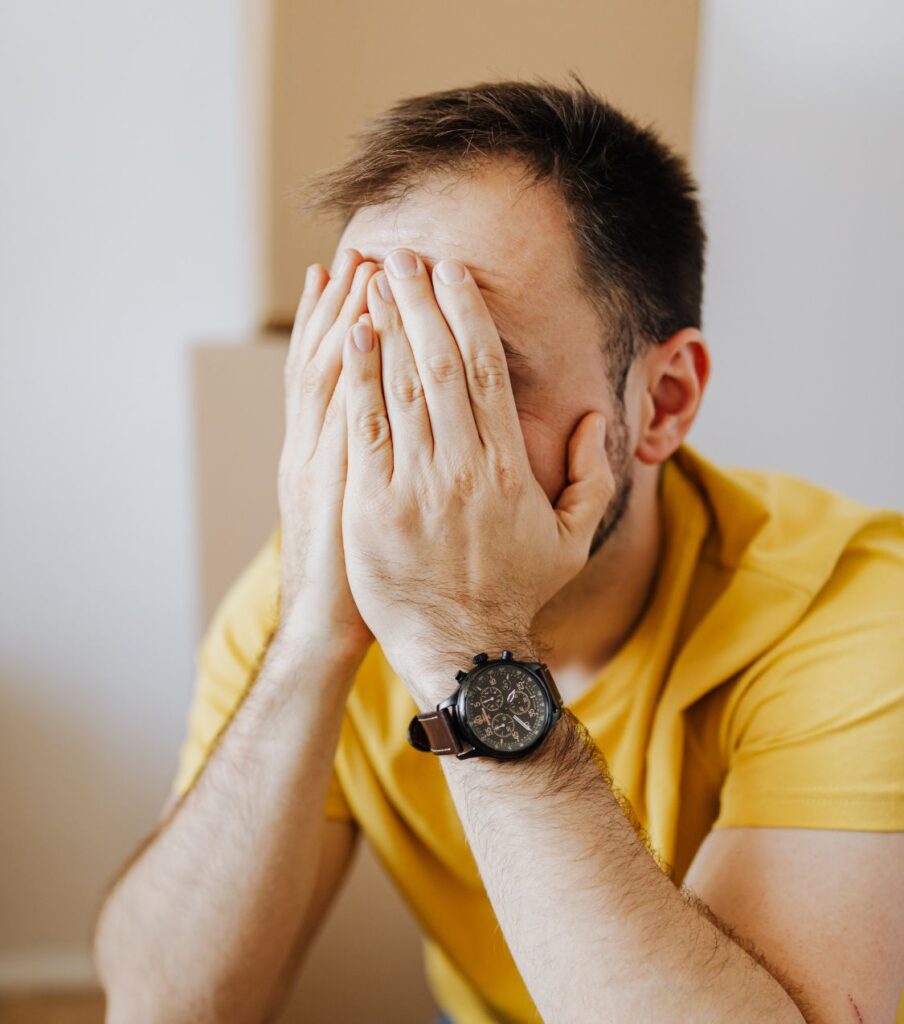 A man covering his face, symbolizing distress after infidelity. Learn how to show remorse after cheating by scheduling a free consultation with Relationship Experts LLC, helping couples in Florida, California, New York, and across the U.S.