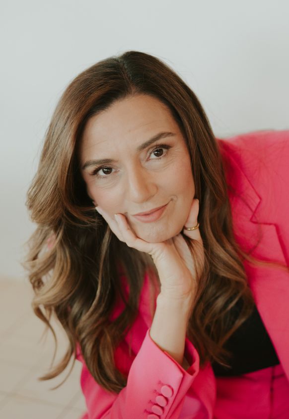 Idit Sharoni, in a pink suit, creator and lead expert of the infidelity recovery program and practice owner. Book a free consultation to start your healing journey in the USA and worldwide.
