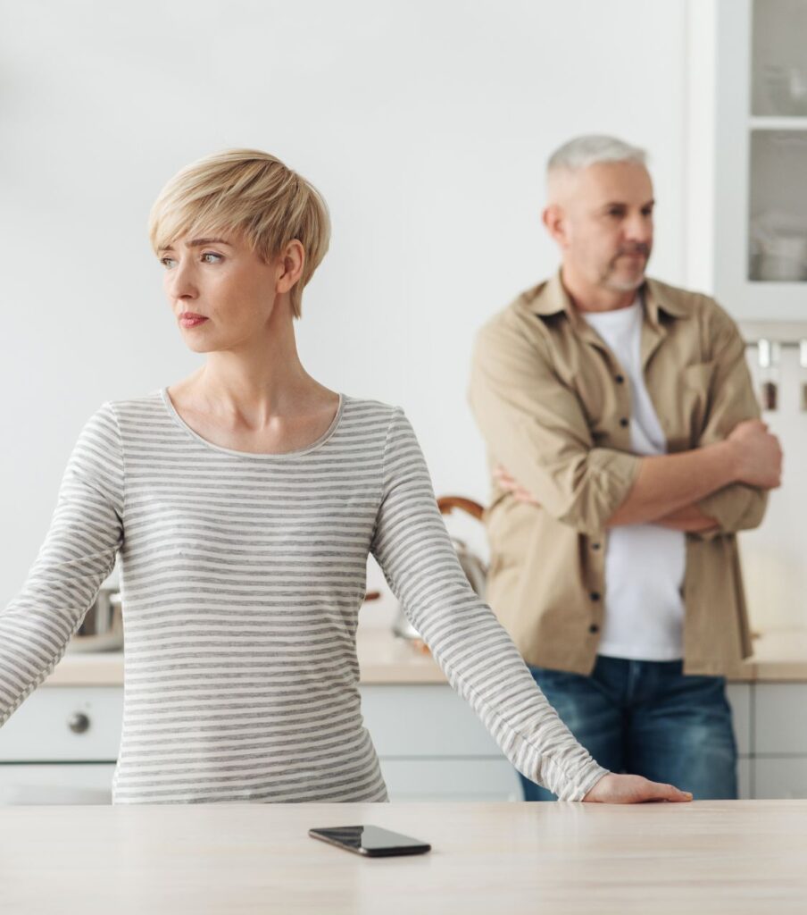 Man stands behind woman | Best therapy for infidelity in the USA | Affair recovery program in Canada | couples therapy in the UK Man stands behind woman with crossed arms, reflecting emotional distance. When typical post-affair therapy fails, our Affair Recovery Program offers lasting reconnection. Serving couples in the US, Canada, the UK, and worldwide. For a best therapy for infidelity, schedule a consultation today.