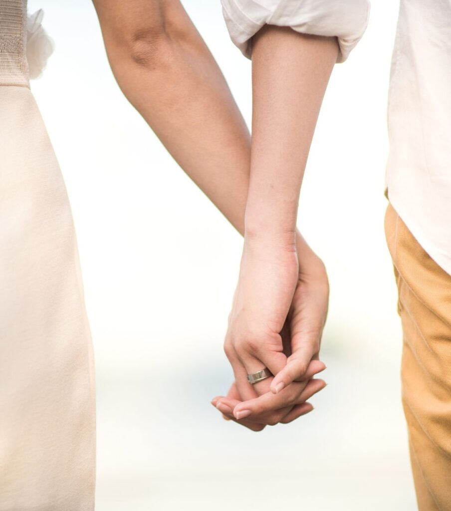 A married couple holding hands. Forgiveness after cheating is possible with the right support. Infidelity recovery program available in the USA, Canada, the UK, and worldwide. Schedule a call with Relationship Experts today.