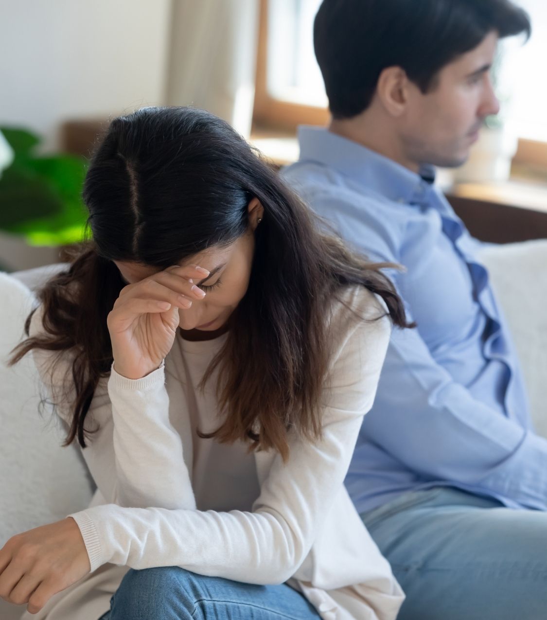 A woman sits next to a man | Affair recovery fails in the US | Proper support in the UK | Online therapy with experts in Canada | Save your marriage in Australia | Worldwide. A woman sits next to a man, leaning her head on her hand. Affair recovery fails without proper support. Online therapy with experts can save your marriage in the USA, the UK, Canada, Australia, and worldwide.