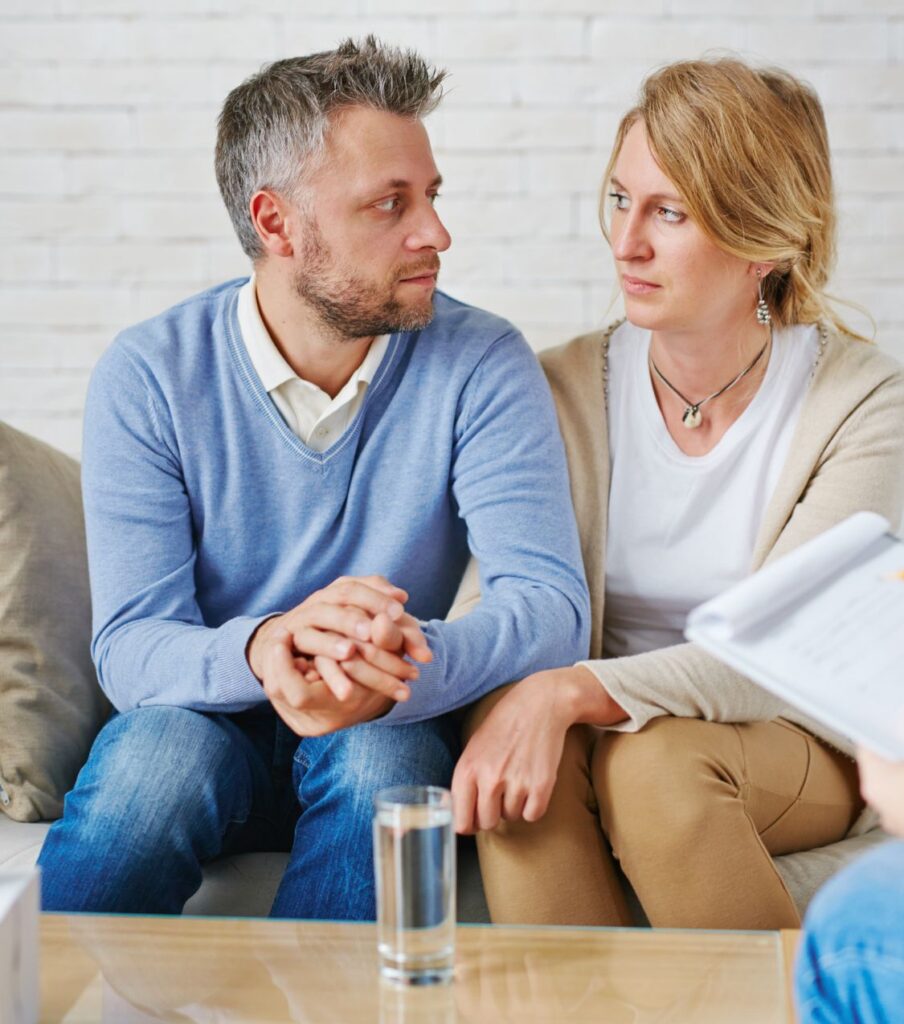A sad couple sitting holding hands, radiating warmth and connection - representing the hope and renewed commitment that couples can reach after surviving a same-sex affair. LGBTQ-affirming affair recovery support for couples in Australia, Dubai, and The UK asking whether a bisexual partner can stay fully committed in a monogamous relationship and how to rebuild trust after same-sex cheating. Explore our Affair Recovery Program today.