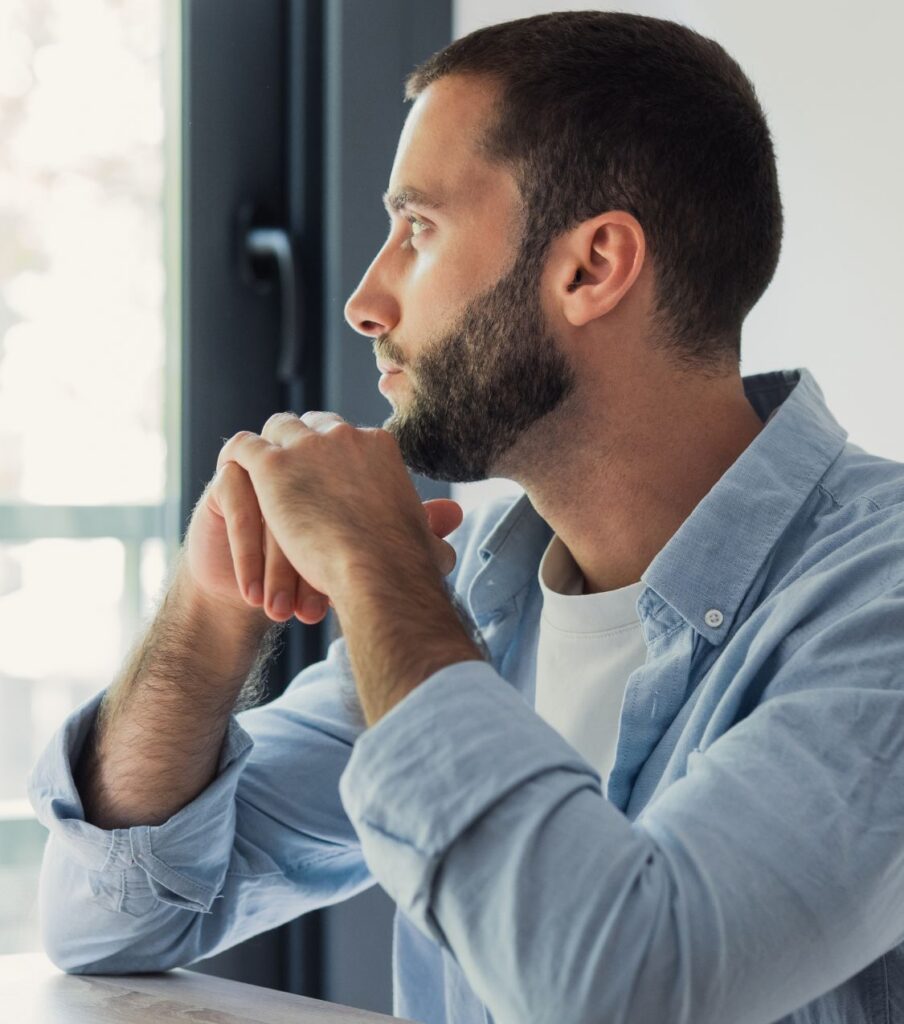 A man sits alone gazing with a troubled expression, reflecting the confusion and grief that follows when a partner cheats with someone of the same sex and questions about attraction, identity, and behavior surface. Expert couples therapists helping clients work through a same-sex affair serve the UK, Dubai, and Bahrain. Take the first step and schedule your consultation now.