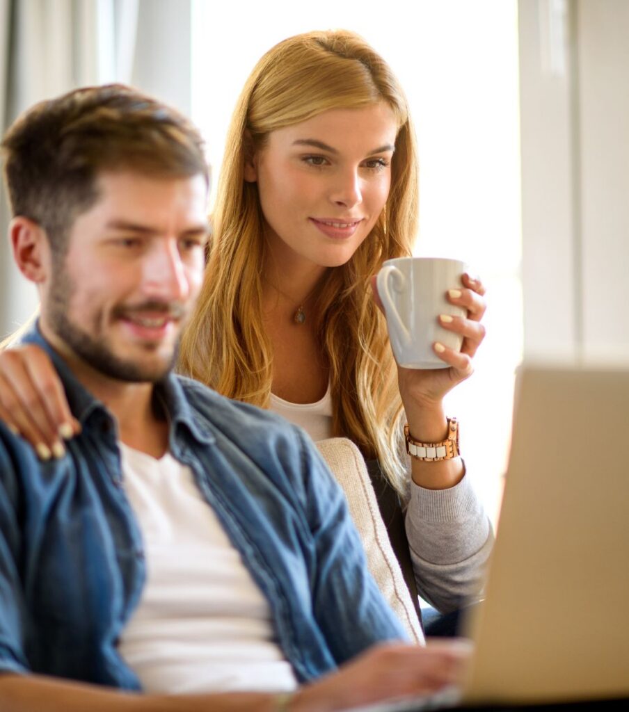 A smiling woman stands behind a seated man with her hand on his shoulder, as they both look at a laptop screen together. Can a straight marriage survive a same sex affair? Find support for when a wife had an affair with a woman or you're exploring sexual fluidity in a straight marriage, for couples in the UK, Canada, and Australia. Book your free 45-minute consultation today.