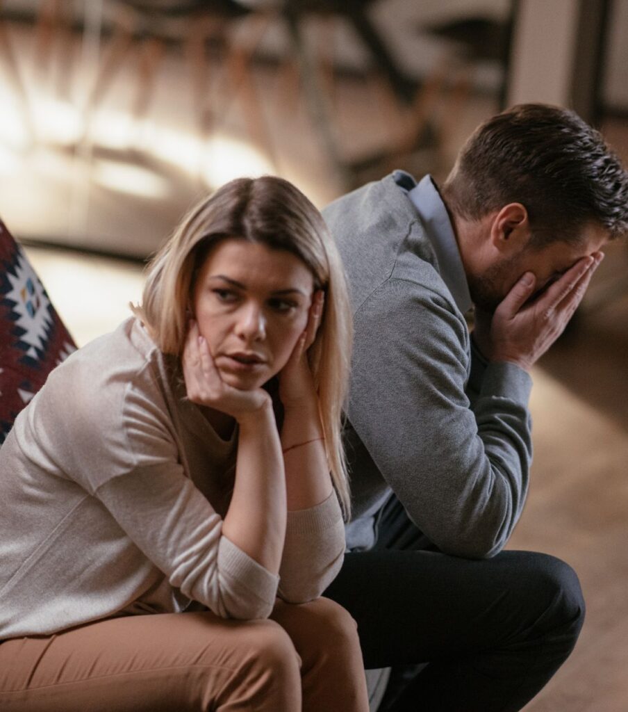 A woman rests her hand on her cheek with a troubled expression while a man behind her holds his face in his hands, both turned away from each other in visible distress. Can a straight marriage survive a same-sex affair? Get answers for when a wife had an affair with a woman, or why would a straight man have an affair with a man. For couples in the USA, UK, and Canada. Start healing with a free, confidential consultation today.